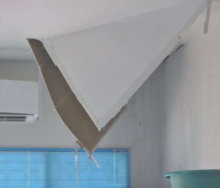 gypsum board on a ceiling is damaged and hanging down
